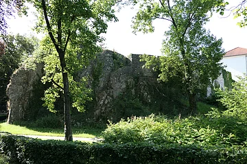 An einen großen Felsblock schließen sich die Mauern einer ehemaligen Burg an.